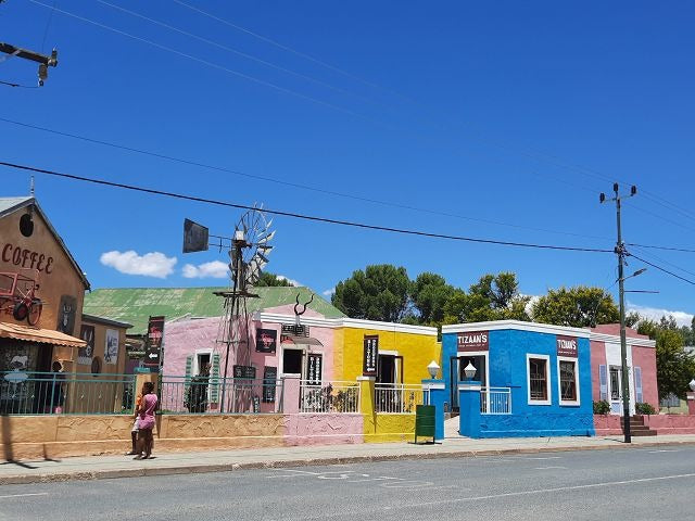 Auf dem Foto der kleine Ort Willowmore im Eastern Cape in Südafrika mit der Windpump und bunten Häusern